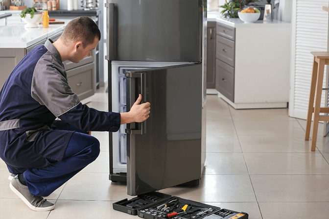 Internal view of refrigerator showing compressor and cooling system for repair in Dubai